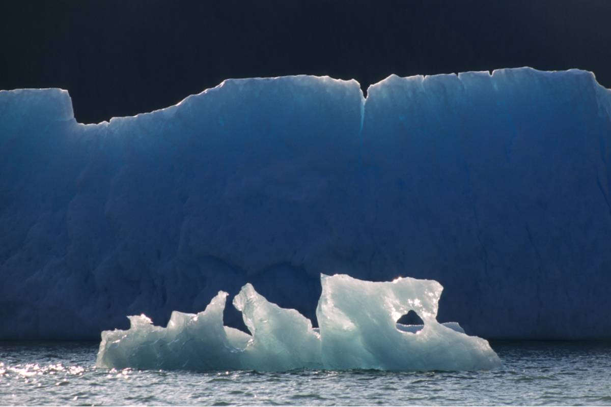 Large iceberg in the background with a smaller ice formation in front of it