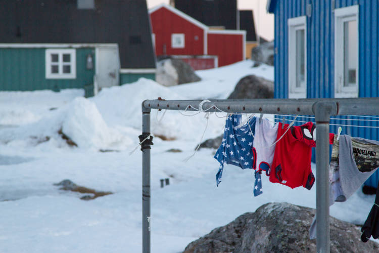 Laundry hanging to dry outside of a home in the arctic, surrounded by snow