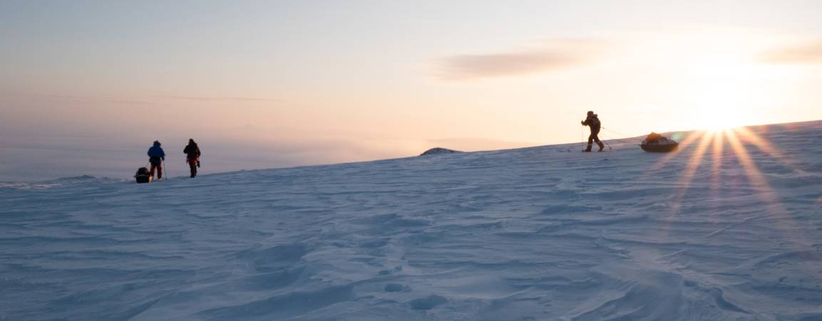 PBI Researchers skiing across Arctic snow at sunrise